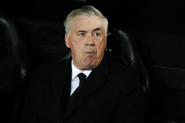 FILE - Real Madrid's head coach Carlo Ancelotti takes his seat on the bench ahead of the La Liga soccer match between Valencia and Real Madrid at the Mestalla Stadium in Valencia, Spain, Saturday, March 2, 2024. Spanish state prosecutors have accused Real Madrid coach Carlo Ancelotti of alleged tax fraud. Prosecutors said in a statement Wednesday, March 6, 2024, that they are accusing Ancelotti of two accounts of tax fraud that would be punishable with four years and nine months of prison. (AP Photo/Jose Breton, File)