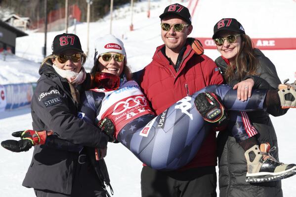 Brother Taylor, flanked by his wife Christie, right, and by her mother Eileen, left, holds the winner United States' Mikaela Shiffrin after an alpine ski, women's World Cup slalom, in Are, Sweden, Saturday, March 11, 2023. (AP Photo/Alessandro Trovati)