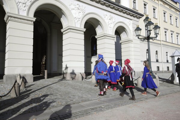 Seven activists representing the Sami Indigenous people arrive at the Royal Castle in Oslo for a meeting with Norway's King Harald and Crown Prince Haakon, in Oslo, Monday, Oct. 16, 2023. Seven of the activists who repeatedly have demonstrated against a wind farm in in central Norway they say hinders the rights of the Sami Indigenous people to raise reindeer, were Monday received by the Norwegian king. At the center of the dispute are the 151 turbines of Europe’s largest onshore wind farm. (Gorm Kallestad/NTB Scanpix via AP)