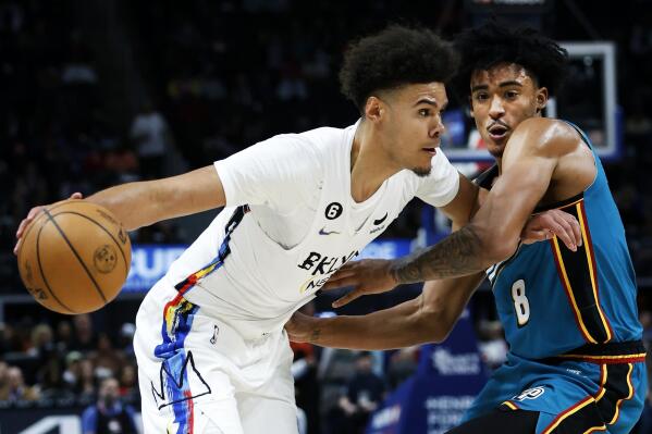Brooklyn Nets forward Cameron Johnson, left, drives against Detroit Pistons guard Jared Rhoden during the first half of an NBA basketball game Wednesday, April 5, 2023, in Detroit. (AP Photo/Duane Burleson)