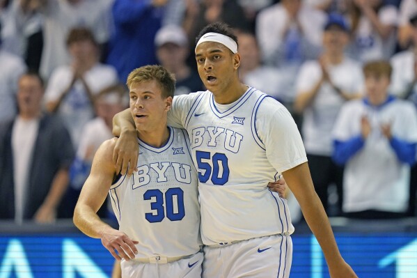 BYU center Aly Khalifa (50) hugs Dallin Hall (30) after scoring against Evansville during the first half of an NCAA college basketball game Tuesday, Dec. 5, 2023, in Provo, Utah. (AP Photo/Rick Bowmer)