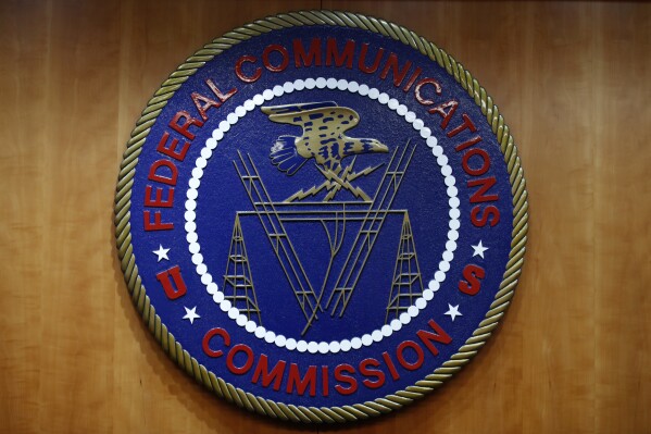 FILE - The seal of the Federal Communications Commission (FCC) is seen before an FCC meeting to vote on net neutrality, Dec. 14, 2017, in Washington. The FCC on Thursday, April 25, 2024 restored “net neutrality” rules that prevent broadband internet providers such as Comcast and AT&T from favoring some sites and apps over others.. (AP Photo/Jacquelyn Martin, File)