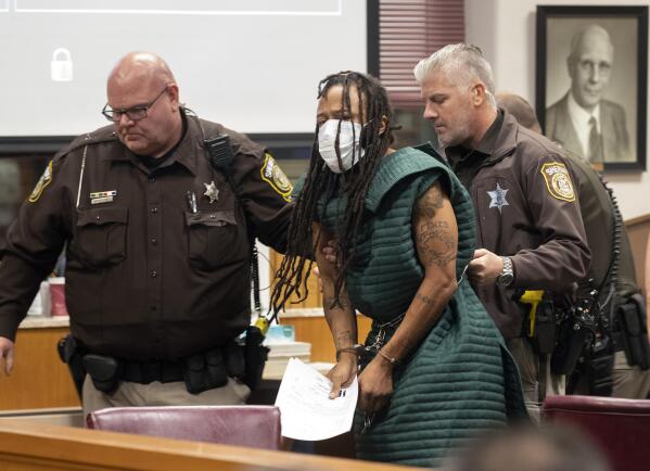 Darrell Brooks, center, is escorted out of the courtroom after making his initial appearance, Tuesday, Nov. 23, 2021 in Waukesha County Court in Waukesha, Wis. Prosecutors in Wisconsin have charged Brooks with intentional homicide in the deaths of at least five people who were killed when an SUV was driven into a Christmas parade. (Mark Hoffman/Milwaukee Journal-Sentinel via AP, Pool)