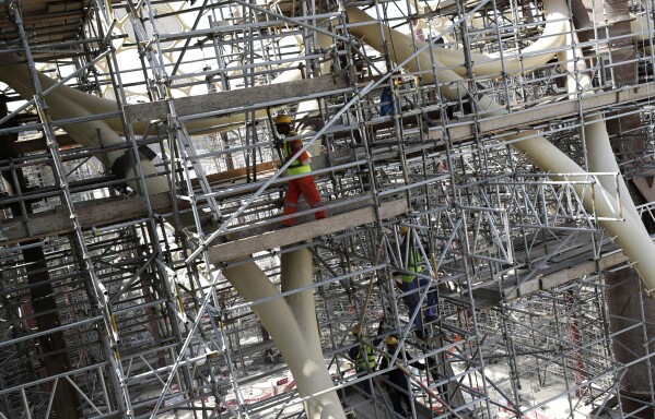 FILE - Laborers work on the Al Wasl Dome at the construction site of the Expo 2020 in Dubai, United Arab Emirates on Oct. 8, 2019. Dubai's Expo City, built for $7 billion for its 2020 world fair delayed a year by the coronavirus pandemic, will host the upcoming climate talks. (AP Photo/Kamran Jebreili, File)