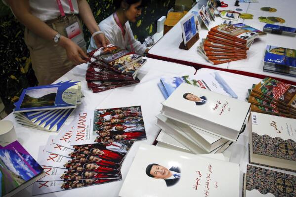 FILE - Copies of the book on the governance of Chinese President Xi Jinping are displayed with booklets promoting Xinjiang during a news conference by Shohrat Zakir, chairman of China's Xinjiang Uighur Autonomous Region, at the State Council Information Office in Beijing on July 30, 2019. As the Chinese government tightened its grip over its ethnic Uyghur population, it sentenced one man to death and three others to life in prison in 2021 for textbooks drawn in part from historical resistance movements that had once been sanctioned by the ruling Communist Party. (AP Photo/Andy Wong, File)