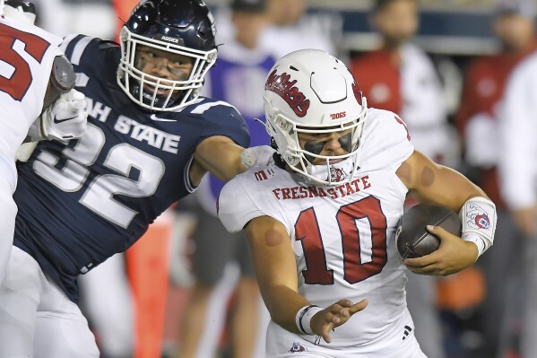 Utah State defensive end Paul Fitzgerald (32) sacks Fresno State quarterback Logan Fife (10) during the first half of an NCAA college football game Friday, Oct. 13, 2023, in Logan, Utah. (Eli Lucero/The Herald Journal via AP)