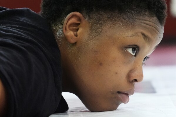North Central women's wrestling team's Tiera Jimerson stretches during a practice at North Central College in Naperville, Ill., Tuesday, March 5, 2024. The team is a national powerhouse even though the program is only a few years old and the school is D-III. (AP Photo/Nam Y. Huh)
