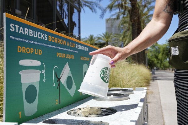 A reusable cup is returned to a borrow a cup return bin at an Arizona State University Starbucks shop Wednesday, June 7, 2023, in Tempe, Ariz. At the Arizona State store, if customers don't bring their own cup, they are given a reusable plastic one with a Starbucks logo. If they bring it back, they get $1 off, just like customers who bring their own. (AP Photo/Ross D. Franklin)