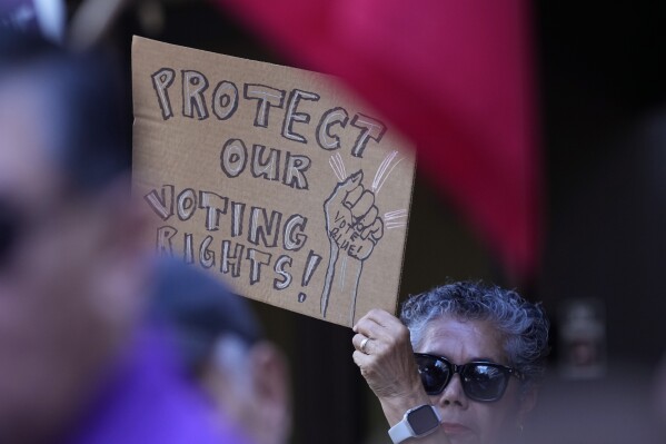 A supporter waves a sign at a news conference, Aug. 26, 2024, in San Antonio. (AP Photo/Eric Gay, file)