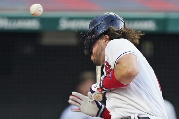 Cleveland Indians' Austin Hedges is hit by a pitch during the third inning of the team's baseball game against the Seattle Mariners, Friday, June 11, 2021, in Cleveland. (AP Photo/Tony Dejak)