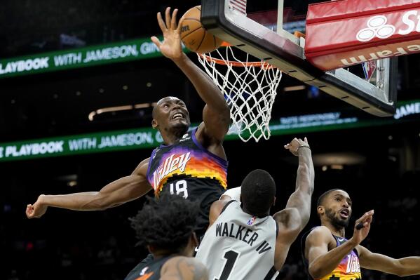 Phoenix Suns center Bismack Biyombo (18) blocks the shot of San Antonio Spurs guard Lonnie Walker IV (1) during the first half of an NBA basketball game, Sunday, Jan. 30, 2022, in Phoenix. (AP Photo/Matt York)