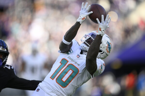 Miami Dolphins wide receiver Tyreek Hill (10) catches a pass for a first down against the Baltimore Ravens during the first half of an NFL football game in Baltimore, Sunday, Dec. 31, 2023. (AP Photo/Nick Wass)