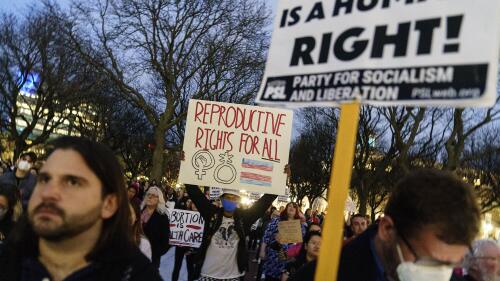 FILE - Tripp Hopkins, center, attends a rally to protest the news that the U.S. Supreme Court could be poised to overturn the landmark Roe v. Wade case that legalized abortion nationwide, May 3, 2022, at the Statehouse in Providence, R.I. On June 24, the Supreme Court overturned Roe v. Wade. The Rhode Island Senate is set to vote Thursday, May 18, 2023, on a measure that would allow state funds to be used to pay for health plans that cover state workers and Medicaid recipients seeking abortions. (AP Photo/David Goldman, File)