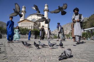 Afghan people walk pass the Shah-Do Shamshira Mosque during the first day of Eid al-Fitr in Kabul, Afghanistan, Friday, April 21, 2023. (AP Photo/Ebrahim Noroozi)