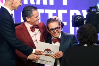 FILE - In this May 21, 2013, file photo, Cleveland Cavaliers owner Dan Gilbert congratulates his son, Nick Gilbert, after the team won the NBA basketball draft lottery in New York. Nicolas “Nick” Gilbert, who became the team's good luck charm at NBA draft lotteries, has died. He was 26. A funeral announcement posted by the Ira Kaufman Chapel said Gilbert died Saturday, May 6, 2023 “peacefully at home surrounded by family.” (AP Photo/Jason DeCrow, File)