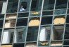 FILE - Workers clean out shattered glass at the Wells Fargo building as clean up from the previous week's storm continues in downtown Houston, Monday, May 20, 2024. (Brett Coomer/Houston Chronicle via AP, file)