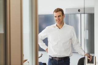 This 2019 photo provided by Moderna shows the company's President Stephen Hoge in his office in Cambridge, Mass. In a May 2021 interview, Hoge says the company is working on developing COVID-19 vaccine booster shots while also trying to harness the genetic code technology it helped pioneer to fight other diseases. (Moderna via AP)