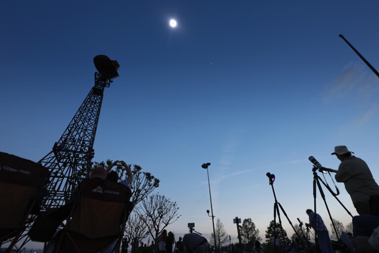 A total solar eclipse is shown over the Paris Eiffel Tower in Paris, Texas, Monday, April 8, 2024. (AP Photo/Tony Gutierrez)