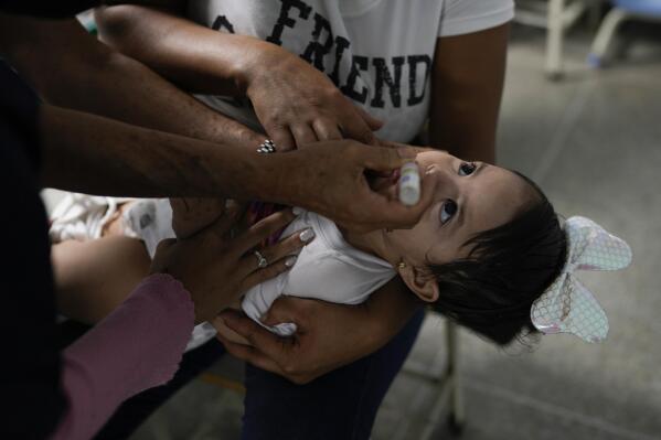 A toddler is inoculated for polio during a free vaccination campaign for polio, rubella and influenza organized by the Health Ministry in Caracas, Venezuela, Saturday, June 18, 2022. An Associated Press analysis of rare government data and estimates from public health agencies shows that Venezuela’s vaccination crisis is growing, putting it among the world’s worst countries for getting required shots that protect young children against potentially fatal diseases. (AP Photo/Ariana Cubillos)