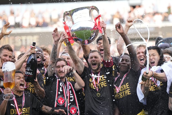 FC Midtjylland's players celebrate winning the Danish Superliga trophy at MCH Arena in Herning, Denmark, on Sunday, May 26, 2024. FC Midtjylland took advantage of a slip-up by Brondby on a dramatic final day in the Danish league season to win the title on Sunday — and the team had a special visitor to mark the occasion. Kristoffer Olsson, the Sweden midfielder in rehabilitation from an acute brain condition, was at the MCH Arena to watch his Midtjylland team draw 3-3 at home to Silkeborg. (Bo Amstrup/Ritzau Scanpix via AP)