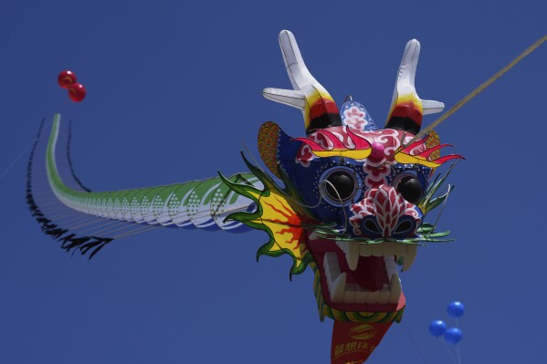A dragon-shaped kite flies in the air at the 41st International Kite Festival in Weifang, Shandong Province of China, Saturday, April 20, 2024. (AP Photo/Tatan Syuflana)