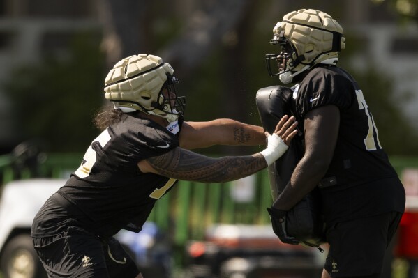 New Orleans Saints offensive tackle Taliese Fuaga, left works on a drill during NFL football training camp, Friday, July 26, 2024, in Irvine, Calif. (ĢӰԺ Photo/Kyusung Gong)