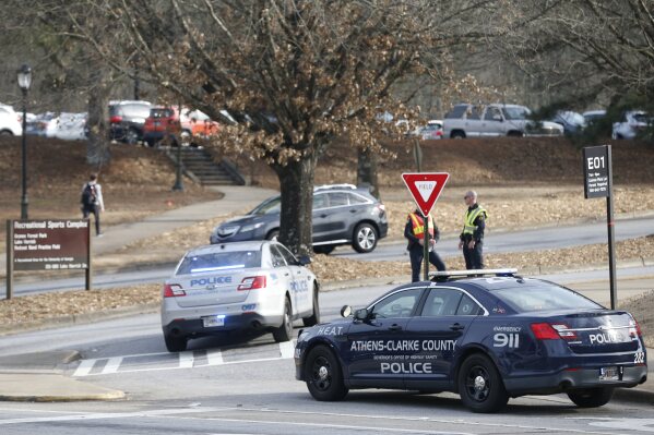 Athens-Clarke County police block traffic and investigate at the UGA intramural Fields after the body of a women was found with found in the woods around Lake Herrick in Athens, Ga., on Thursday, Feb. 22, 2024. (Joshua L. Jones/Athens Banner-Herald via AP)