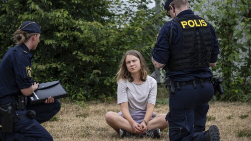 FILE - Police officers talk to the Swedish climate activist Greta Thunberg as they move activists from the organization 'Ta Tillbaka Framtiden' (Take back the future) who are blocking the entrance to the Oljehamnen neighbourhood in Malmo, Sweden, Monday, June 19, 2023. Local newspaper Sydsvenskan reported Wednesday, July 5, 2023, that Swedish prosecutors have charged Thunberg with disobedience to law enforcement in connection with a protest in Malmö last month. (Johan Nilsson/TT News Agency via AP, File)