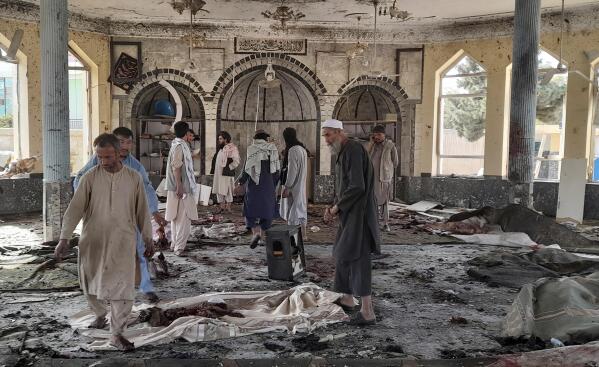 People view the damage inside of a mosque following a bombing in Kunduz, province northern Afghanistan, Friday, Oct. 8, 2021. A powerful explosion in the mosque frequented by a Muslim religious minority in northern Afghanistan on Friday has left several casualties, witnesses and the Taliban's spokesman said. (AP Photo/Abdullah Sahil)