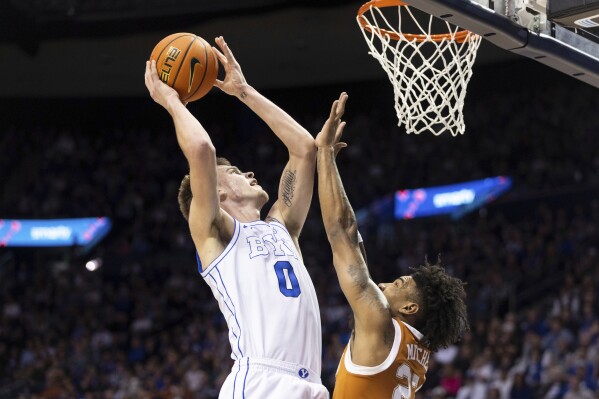 BYU forward Noah Waterman (0)looks to shoot against Texas forward Dillon Mitchell, right, during an NCAA college basketball game in Provo, Utah, Saturday, Jan. 27, 2024. (Marielle Scott/The Deseret News via AP)