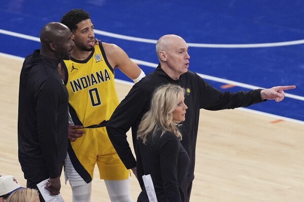 Indiana Pacers head coach Rick Carlisle, right, motions to players on the court as assistant coach Lloyd Pierce, far left, talks with guard Tyrese Haliburton (0) during the third quarter of Game 5 of the NBA basketball Eastern Conference finals against the New York Knicks, Thursday, May 29, 2025, in New York. (AP Photo/Frank Franklin II)