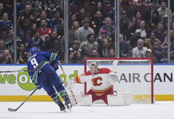 Vancouver Canucks' J.T. Miller (9) shoots against Calgary Flames goalie Jacob Markstromduring the third period of an NHL hockey game Tuesday, April 16, 2024, in Vancouver, British Columbia. (Darryl Dyck/The Canadian Press via AP)