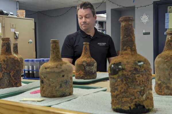 Archeologist Jason Boroughs discusses artifacts found underneath George Washington's residence in Mount Vernon, Va., Monday, June 17, 2024. Earlier this year, a few dozen 18th-century glass bottles containing fruit were unearthed in the mansion cellar of the America's first president.(AP Photo/Nathan Ellgren)