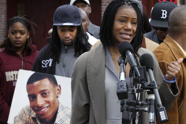 FILE - In this April 21, 2011, file photo, Thulani DeMarsay, right, aunt of Danroy "DJ" Henry Jr., who was shot and killed by a police officer, speaks as Henry's uncle Jamele Dozier, left, holds a photograph of Henry during a news conference in Boston's Roxbury neighborhood. Celebrities including Rihanna, Jay-Z and Charlize Theron have called for the U.S. Department of Justice in July 2020, to investigate the case of Henry, a black Pace University football player killed by a white police officer in New York after the team's homecoming game in October 2010. (AP Photo/Steven Senne, File)