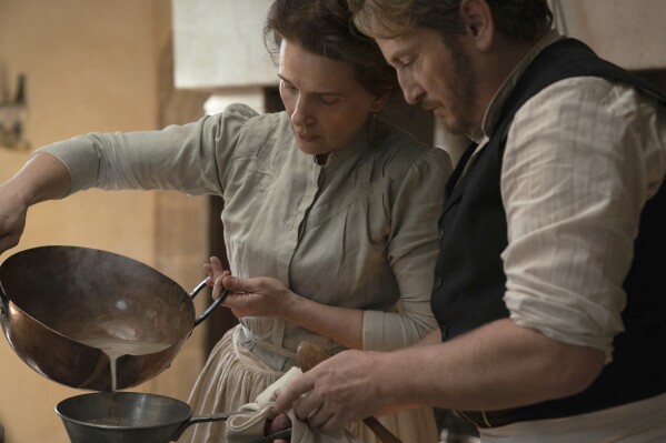 This image released by IFC Films shows Juliette Binoche, left, and Benoît Magimel in a scene from "The Taste of Things." (Stéphanie Branchu/IFC Films via AP)