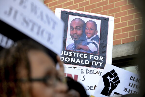 A demonstrator holds a sign in support of Donald "Dontay" Ivy Jr. during a rally outside Albany District Attorney David Soares' office in Albany, N.Y., on Monday, Aug. 10, 2015. Ivy was cooperative when police stopped him, but, they said, he wouldn’t answer how much money he had withdrawn from an ATM and denied a prior arrest. Police interpreted Ivy’s behavior as deceptive. What they didn’t grasp was that Ivy suffered from paranoid schizophrenia. After an officer touched Ivy to detain him, Ivy fled. Officers caught up and beat him with batons, shocked him several times with a Taser, put him facedown and got on top of him. (Will Waldron/The Albany Times Union via AP)