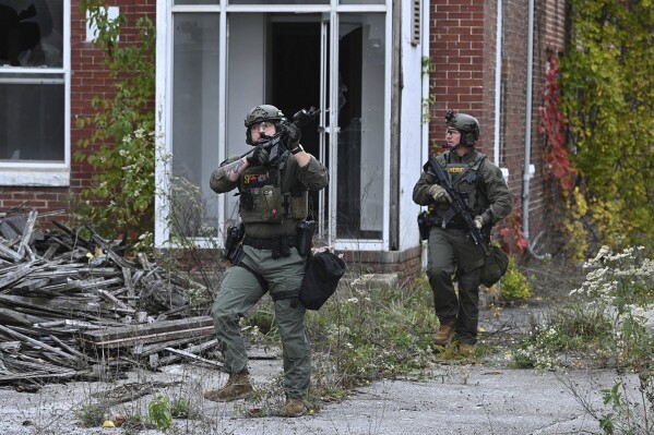 Officers with the Frederick County Sheriiff's Dept. SWAT Team search for suspect Pedro Argote at the former Garden State Tannery plant in Williamsport, Md. on Saturday, Oct. 21, 2023. Washington County Sheriff Brian Albert said authorities are “actively working” to apprehend 49-year-old Pedro Argote for the “targeted attack” of Maryland Circuit Court Judge Andrew Wilkinson. (Ric Dugan/The Frederick News-Post via AP)