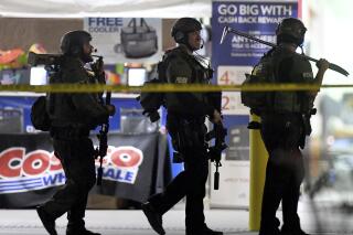FILE - Heavily armed police officers leave the Corona, Calif., Costco store following the fatal shooting of Kenneth French by an off-duty Los Angeles Police officer, June 14, 2019. A judge says a former Los Angeles police officer who was off duty when he fatally shot French during a confrontation at the Costco store must stand trial on manslaughter and other charges. (Will Lester/The Orange County Register/SCNG via AP, File)