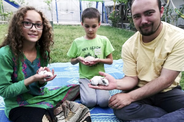 This family photo shows Ryan Corbett holding rabbits with his daughter Miriam and son Caleb in Kabul, Afghanistan in 2020. Lawyers for Corbett, believed held by the Taliban for nearly two years, are asking a United Nations human rights investigator to intervene, citing what they say is cruel and inhumane treatment. Corbett was abducted on August 10, 2022 after returning to Afghanistan, where he and his family had been living at the time of the collapse of the U.S.-based government there one year earlier, on a valid 12-month business visa to pay and train staff. (AP Photo/Anna Corbett)