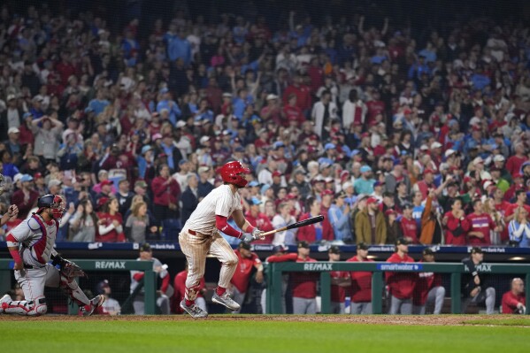 Philadelphia Phillies' Bryce Harper follows through after hitting the game-winning RBI-sacrifice fly against Washington Nationals pitcher Kyle Finnegan during the 10th inning of a baseball game, Saturday, May 18, 2024, in Philadelphia. (AP Photo/Matt Slocum)