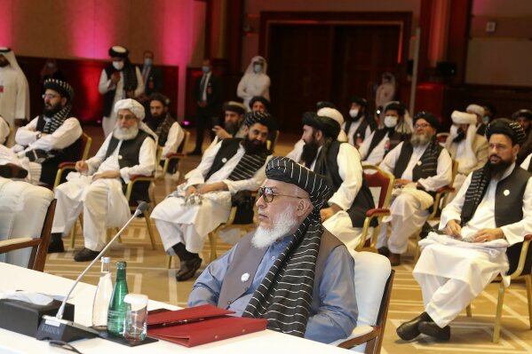 FILE - In this Sept. 12, 2020, file photo, Taliban negotiator Abbas Stanikzai, center front, and his delegation attend the opening session of peace talks between the Afghan government and the Taliban, in Doha, Qatar. Afghanistan’s Taliban on Thursday, Oct. 8, 2020, welcomed a tweet from President Donald Trump in which he promised to have the last of the U.S.'s troops out of Afghanistan by Christmas. If that withdrawal happens, it would be months ahead of schedule and the tweet made no reference to a Taliban promise to fight terrorist groups — a previous pre-requisite for an American withdrawal. (AP Photo/Hussein Sayed, File)