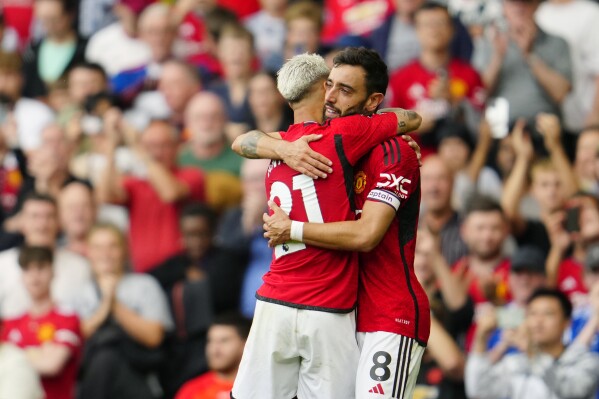 Manchester United's Bruno Fernandes celebrates with Manchester United's Antony after scoring his side's third goal during the English Premier League soccer match between Manchester United and Nottingham Forest at the Old Trafford stadium in Manchester, England, Saturday, Aug. 26, 2023. (AP Photo/Jon Super)
