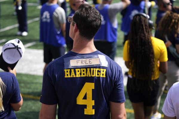 A fan tapes the word Free to a Jim Harbaugh shirt in the first half of an NCAA college football game against the East Carolina in Ann Arbor, Mich., Saturday, Sept. 2, 2023. (AP Photo/Paul Sancya)
