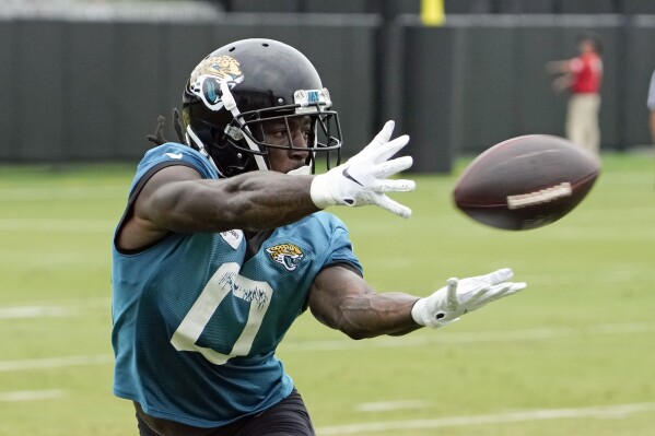 Jacksonville Jaguars wide receiver Calvin Ridley (0) makes a catch during a passing drill in practice at the NFL football team's training camp, Monday, July 31, 2023, in Jacksonville, Fla. (AP Photo/John Raoux)