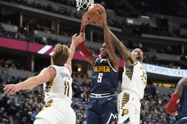 Denver Nuggets forward Will Barton, center, pulls in a rebound between Indiana Pacers forwards Domantas Sabonis, left, and Torrey Craig in the second half of an NBA basketball game Wednesday, Nov. 10, 2021, in Denver. (AP Photo/David Zalubowski)