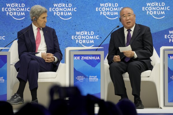 FILE - John Kerry, Special Presidential Envoy for Climate of the United States, left, listens to Xie Zhenhua, Special Envoy for Climate Change for China, during the World Economic Forum in Davos, Switzerland, May 24, 2022. Kerry and Xie are stepping down from their roles, marking a generational shift in the world of international climate negotiations. Activists and scientists hope that the world's two biggest emitters of greenhouse gases continue finding ways to collaborate to prevent the planet from heating up to catastrophic levels. (AP Photo/Markus Schreiber, File)