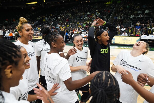 Seattle Storm players, including center Mercedes Russell, third from left, guard Jewell Loyd, guard Nika Muhl, guard Jordan Horston and guard Sami Whitcomb, right, laugh as they huddle before facing the Phoenix Mercury in a WNBA basketball game Tuesday, June 4, 2024, in Seattle. (AP Photo/Lindsey Wasson)