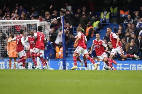 Arsenal's Bukayo Saka, third from left back to the camera, celebrates with teammates after scoring the opening goal during the English Premier League soccer match between Chelsea and Arsenal at Stamford Bridge Stadium in London, Sunday, Nov. 6, 2022. (AP Photo/Kirsty Wigglesworth)