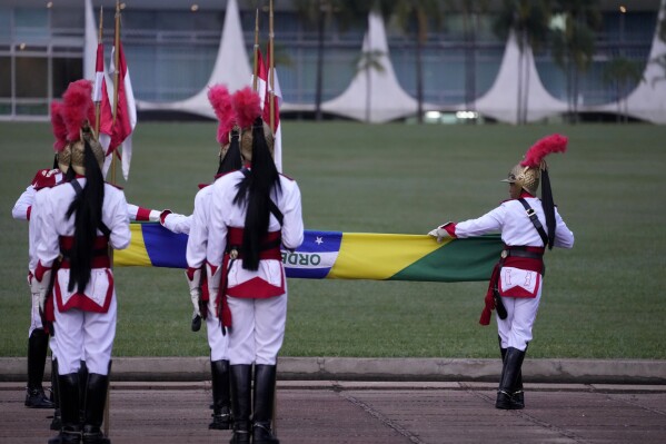 Soldiers from the presidential guard take part in the ceremony to unveil the Brazilian flag in front of the official residence of the Alvorada Palace, where Brazil's President Luiz Inacio Lula da Silva is recovering from surgery after being discharged from hospital, in Brasilia, Brazil, Sunday, Oct. 1, 2023. (AP Photo/Eraldo Peres)