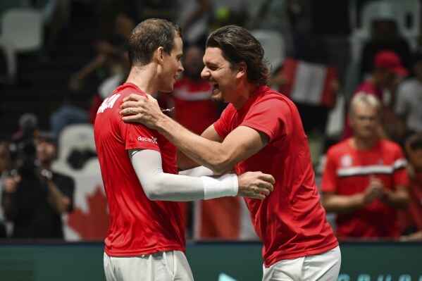 Canada's Frank Dancevic, right, congratulates Canada's Vasek Pospisil after he defeated Sweden's Leo Borg with during their Davis Cup group stage tennis match at the Unipol Arena, Bologna, Italy, Thursday, Sept. 14. 2023. (Massimo Paolone/LaPresse via AP)
